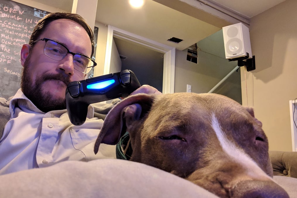 David Biastock playing video games at home and relaxing with his dog