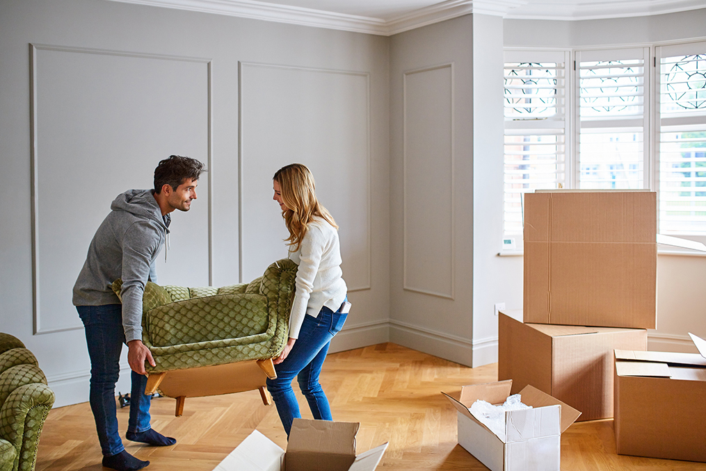 couple moving into their new home placing their modern green chair in the living room