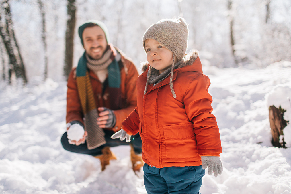 father and son playing in the snow