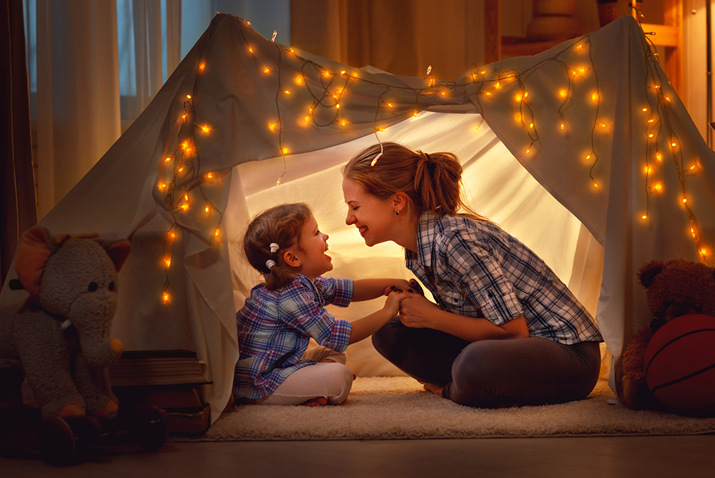 mother and daughter hanging out in a fort they built in their living room