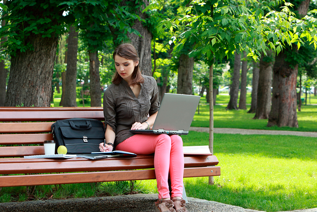 sitting on a park bench organizing finances during her lunch break