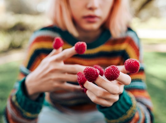woman with fruit in fingers