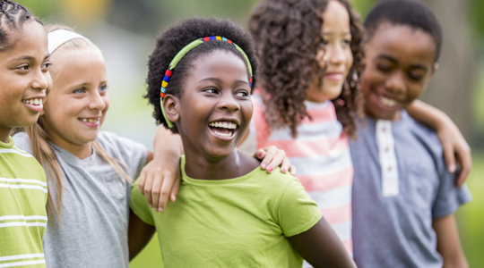 group of young children laughing and posing for a photo