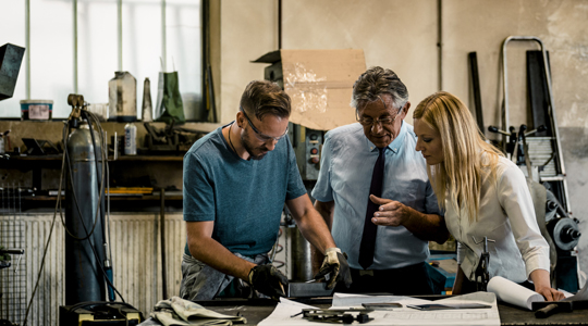 manager and employees working in a machine shop