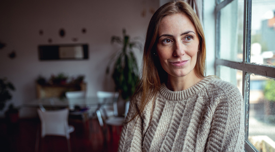 Woman in sweater looks beyond the camera