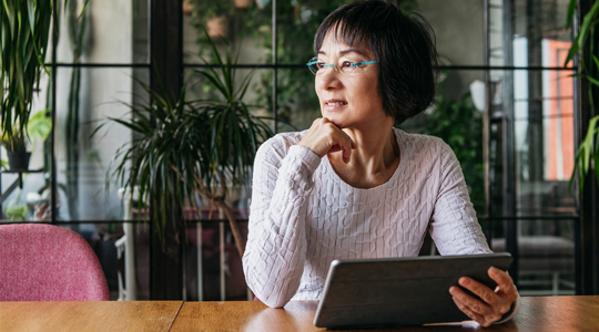 Woman on tablet looking toward the distance