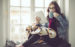 Young woman at home reading tablet and drinking from a coffee mug.