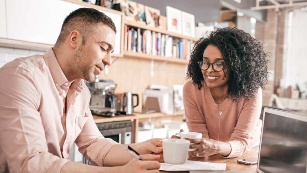 sitting-together-in-their-kitchen-considering-selling-their-home-and-buying-a-new-one_