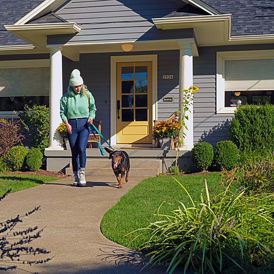 woman leaving home to walk her dog-540x540