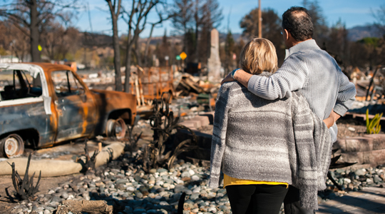 family looking at aftermath of house fire