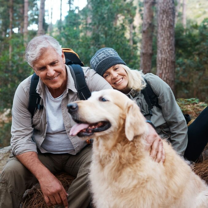 older couple hiking with dog