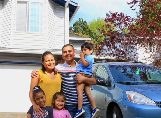 Family helped by Hacienda CDC stands in front of their home