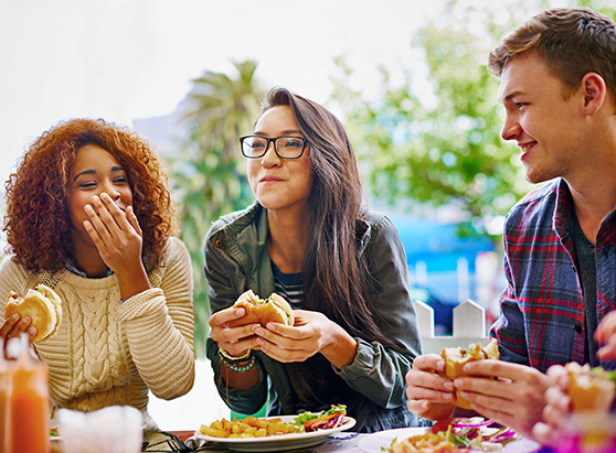 friends having a good time while out at a restaurant eating burgers