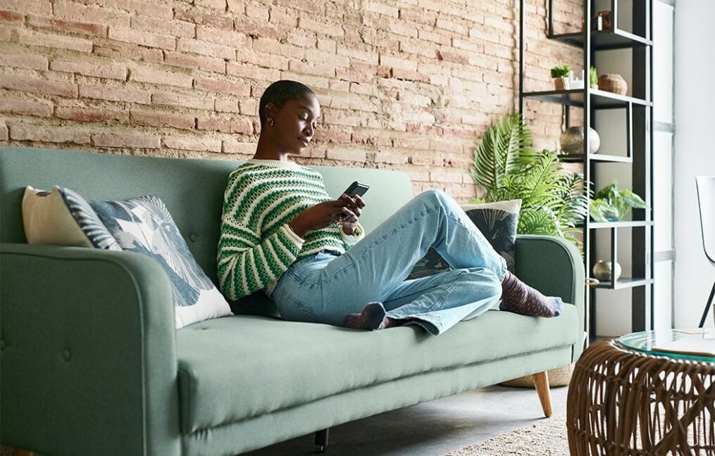 woman-on-couch-looking-at-cell-phone