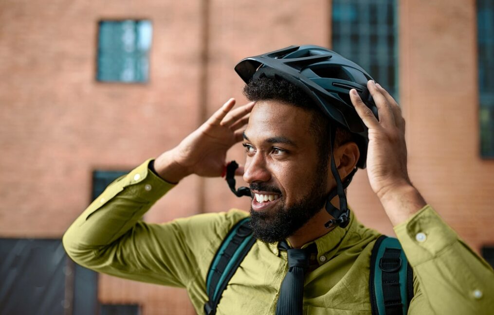 man on a bicycle touching his helmet