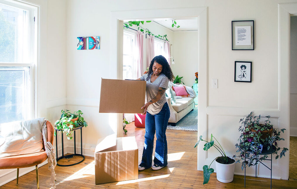 woman moving boxes in her new home