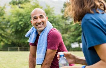 man and woman talking in a field after working out