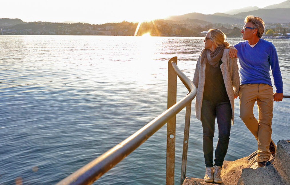 couple looking over shoulder at sunset near a bay