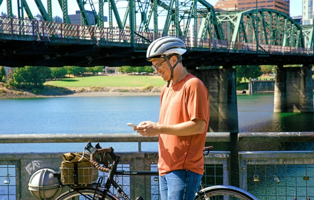 member assistance-man standing on east waterfront in Portland Oregon checking his phone