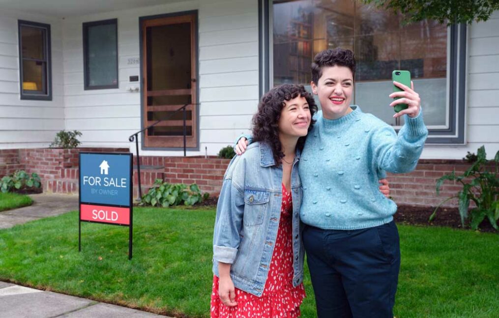 mortgage loans-couple standing outside their new home after receiving an OnPoint mortgage home loan