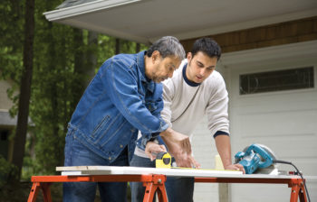 two men working with wood on saw horses