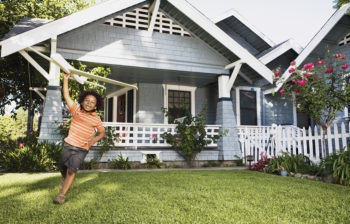 running child carrying glider in front yard
