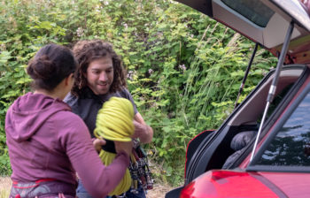 man and woman placing items into a hatch back car