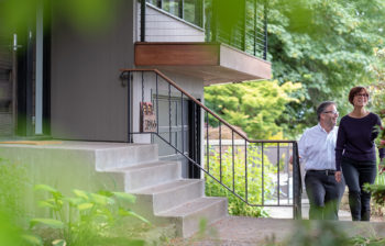man and woman walking up steps to home