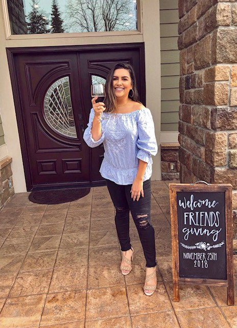 marnie fairbrother standing near a chalkboard sign that she designed