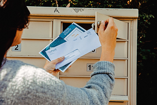 woman removing mail from a locked mailbox