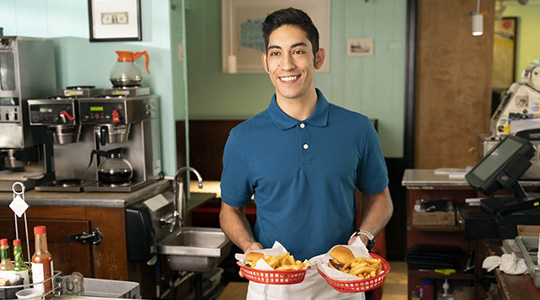 small business financing-employee serving burgers and fries at local small business diner