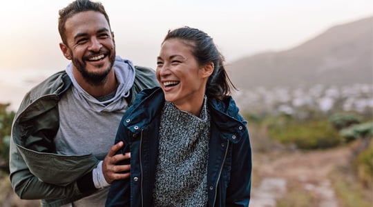 couple traveling enjoying anywhere access with their OnPoint credit card-walking up a mountain near a small coastal town