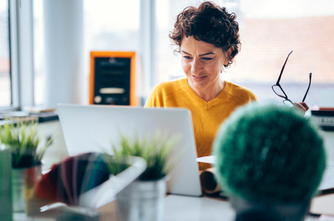 woman sitting at her desk considering applying for funding for her charity organization