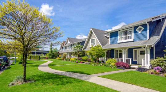 row of homes on sunny street with blue sky