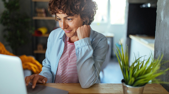 woman sitting at her desk looking at her computer