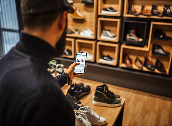 man in shoe store comparing options on phone