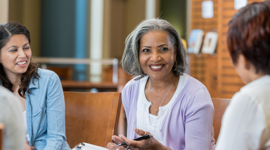 mature educator speaking with other staff members