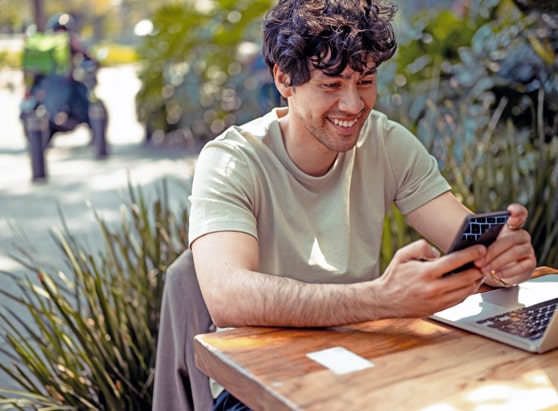 smiling man paying a bill using digital banking with his smartphone