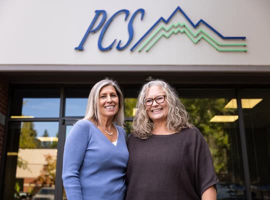Two Pacific Crest Services business members standing outside the PCS office.